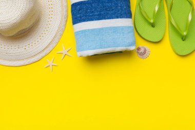 Yaz tatili konsepti düzdü. Hasır şapka plaj aksesuarları ve havlunun üstü. Mesaj için yer var. seyahat kavramı.