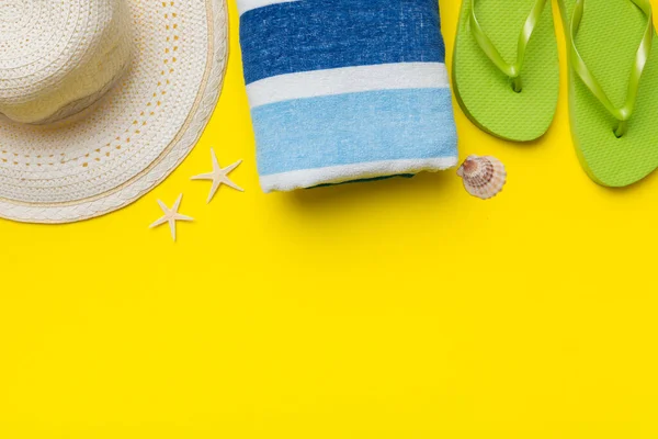 Yaz tatili konsepti düzdü. Hasır şapka plaj aksesuarları ve havlunun üstü. Mesaj için yer var. seyahat kavramı.