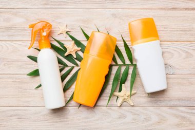 Güneş kremi şişesi. Güneş korumalı krem ve tropik yeşil yapraklı deniz kabukları olan bir şişe..