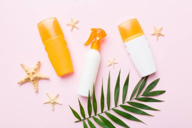 Güneş kremi şişesi. Güneş korumalı krem ve tropik yeşil yapraklı deniz kabukları olan bir şişe..