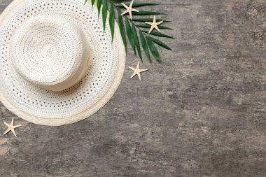 Summer holidays. Summer concept with straw hat and tropical leaf. Flat lay, top view, copy space.
