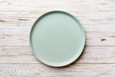 Ahşap zemindeki boş mavi tabağın üst görüntüsü. Tasarımın için boş boşluk.