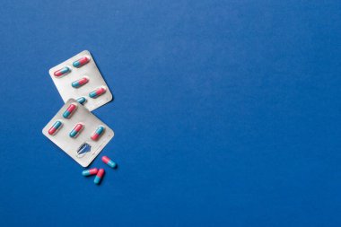 Masa arkasında koruyucu yüz maskeleri, cerrahi maskeler, ilaç hapları ve termometre. Coronavirus hastalığı. Corona virüsü konsepti. Metin için boşluk.