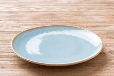 Ahşap zemin üzerinde boş mavi plakanın perspektif görüntüsü. Tasarımın için boş boşluk.