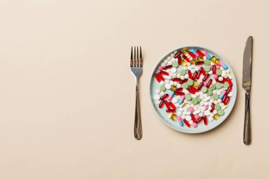 Yuvarlak tabakta yemek olarak birçok farklı kilo kaybı hapı ve takviye maddesi var. Haplar sağlıklı bir yemek olarak sunuldu. Uyuşturucu, eczane, ilaç veya sağlık hizmetleri kavramı.