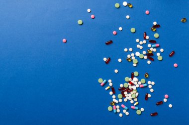 Çeşitli haplar ve tabletler renkli arka planda en üst sınırda. Renkli arkaplan, üst görünüm metni için çok farklı hap ve boşluk.