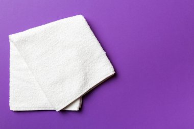 Renkli arkaplanda kopyalama alanı olan beyaz havluların üst görünümü.