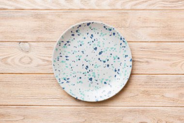 Ahşap zemindeki boş mavi tabağın üst görüntüsü. Tasarımın için boş boşluk.