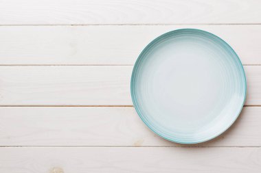 Ahşap zemindeki boş mavi tabağın üst görüntüsü. Tasarımın için boş boşluk.