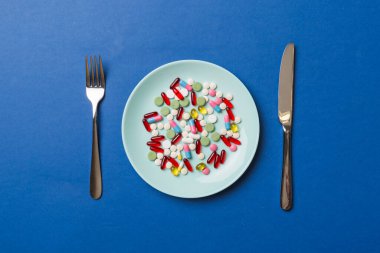 Yuvarlak tabakta yemek olarak birçok farklı kilo kaybı hapı ve takviye maddesi var. Haplar sağlıklı bir yemek olarak sunuldu. Uyuşturucu, eczane, ilaç veya sağlık hizmetleri kavramı.