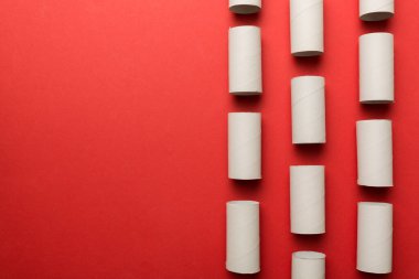 Boş tuvalet kağıdı ruloları ve renk arkaplanı üzerine metin için alanı olan düz bir kompozisyon. Kraft kağıdı veya kartondan yapılmış metal kapaklı geri dönüşümlü kağıt tüp.