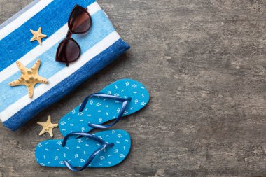 Yaz yolculuğu konsepti. Parmak arası terlikler, güneş gözlükleri ve beyaz üzerine deniz yıldızı. Renkli arkaplanda üst görünüm.