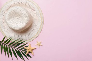 Summer holidays. Summer concept with straw hat and tropical leaf. Flat lay, top view, copy space.