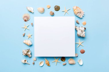 Yaz mevsimi konsepti, boş tebrik kartı ve renkli arkaplan üzerine boş beyaz kağıt. Çerçeve şeklinde deniz kabukları metin üstü görünümü için boşluk ile ayrılmış.