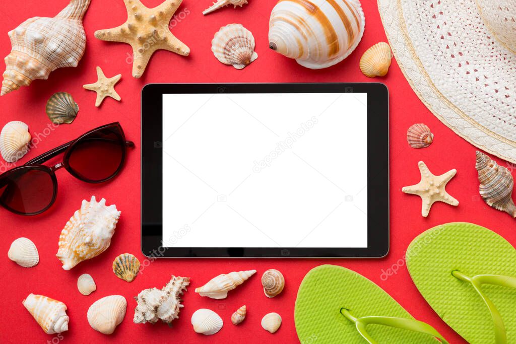 Flat lay composition with tablet and beach accessories on colored background. Tablet computer with blank screen mock up with copy space.