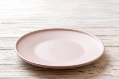 Ahşap arka planda boş pembe plaka manzarası. Tasarımın için boş boşluk.