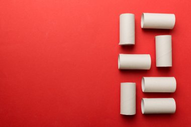 Boş tuvalet kağıdı ruloları ve renk arkaplanı üzerine metin için alanı olan düz bir kompozisyon. Kraft kağıdı veya kartondan yapılmış metal kapaklı geri dönüşümlü kağıt tüp.