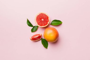 Renkli arka planda sulu greyfurt dilimli taze meyve greyfurdu. Üst Manzara. Uzayı kopyala yaratıcı yaz konsepti. Minimum düzlükte turunçgillerin yarısı kopyalama alanı ile yatar.
