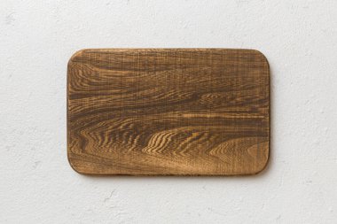 Çimento arka planında ahşap kesim tahtasının üst görüntüsü. Tasarımın için boş boşluk.