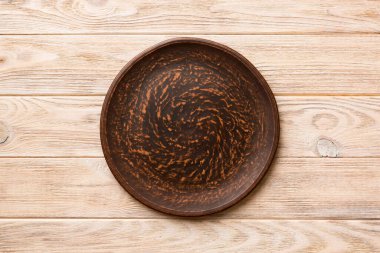 Ahşap zemindeki boş tabağın üst görünümü. Tasarımın için boş boşluk.