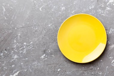 Çimento arka planındaki boş sarı plakanın üst görüntüsü. Tasarımın için boş boşluk.
