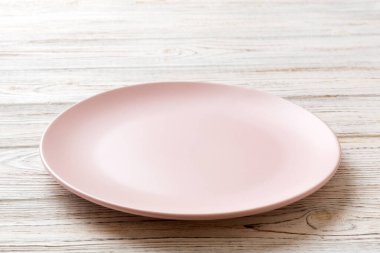 Ahşap arka planda boş pembe plaka manzarası. Tasarımın için boş boşluk.