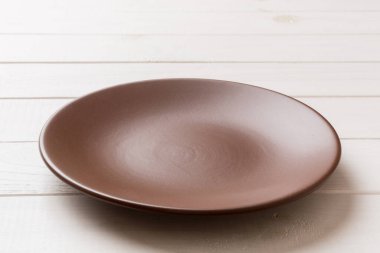 Ahşap zemindeki boş tabağın perspektif görüntüsü. Tasarımın için boş boşluk.