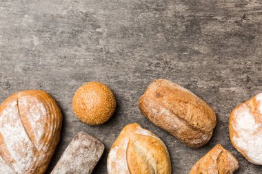 Ev yapımı doğal ekmek. Arka plan olarak farklı taze ekmek türleri, kopya alanı ile üst görünüm.