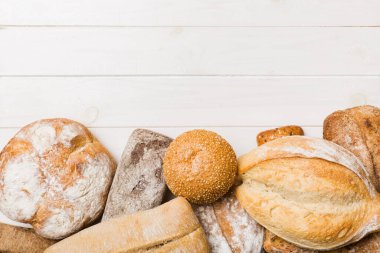 Ev yapımı doğal ekmek. Arka plan olarak farklı taze ekmek türleri, kopya alanı ile üst görünüm.