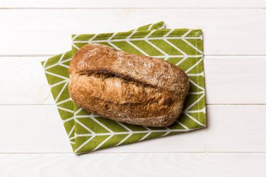 Taze ev yapımı tam buğday ekmeği. Peçetedeki ekmek kırsal arka planda, taze ekmek üst görünümü.