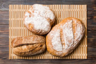 Kırsal masa manzaralı peçeteli taze pişmiş ekmek çeşitleri. Sağlıklı mayasız ekmek. Fransız ekmeği.