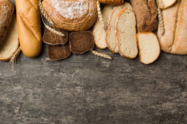 Ev yapımı doğal ekmek. Arka plan olarak farklı taze ekmek türleri, kopya alanı ile üst görünüm.