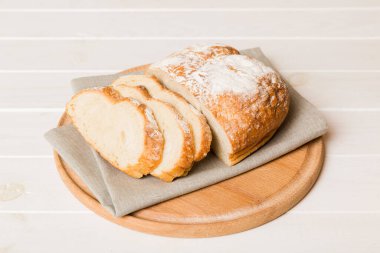 Köy manzaralı peçeteli taze dilimlenmiş ekmek çeşitleri. Sağlıklı mayasız ekmek. Fransız ekmeği dilimi.