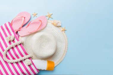 Plaj aksesuarları renkli arka plan yaz seyahati konseptinde düz bir görünüm sergiliyordu. İçinde deniz yıldızı ve deniz kabuğu olan bir çanta. Üst görünüm.