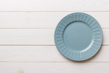 Ahşap zemindeki boş gri tabağın üst görüntüsü. Tasarımın için boş boşluk.