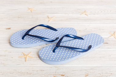 Plaj aksesuarları. Renkli arka planda parmak arası terlik ve denizyıldızı. Üst görünüm Kopyalama alanı ile modelle.