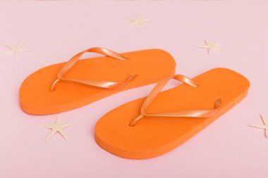 Plaj aksesuarları. Renkli arka planda parmak arası terlik ve denizyıldızı. Üst görünüm Kopyalama alanı ile modelle.