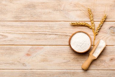 Tahta kasede buğday unu ve renkli arka planda buğday dikenleri. dünya buğday krizi.