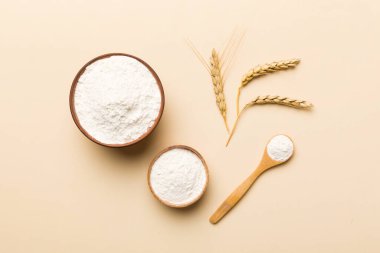 Tahta kasede buğday unu ve renkli arka planda buğday dikenleri. dünya buğday krizi.