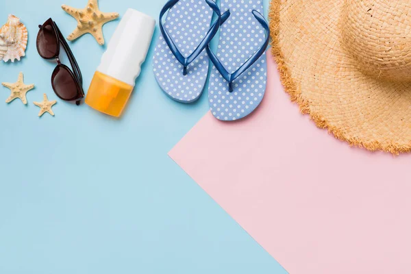 Yaz tatili konsepti düzdü. Hasır şapka plaj aksesuarları ve ters dönmüş üst manzara. Mesaj için yer var. seyahat kavramı.