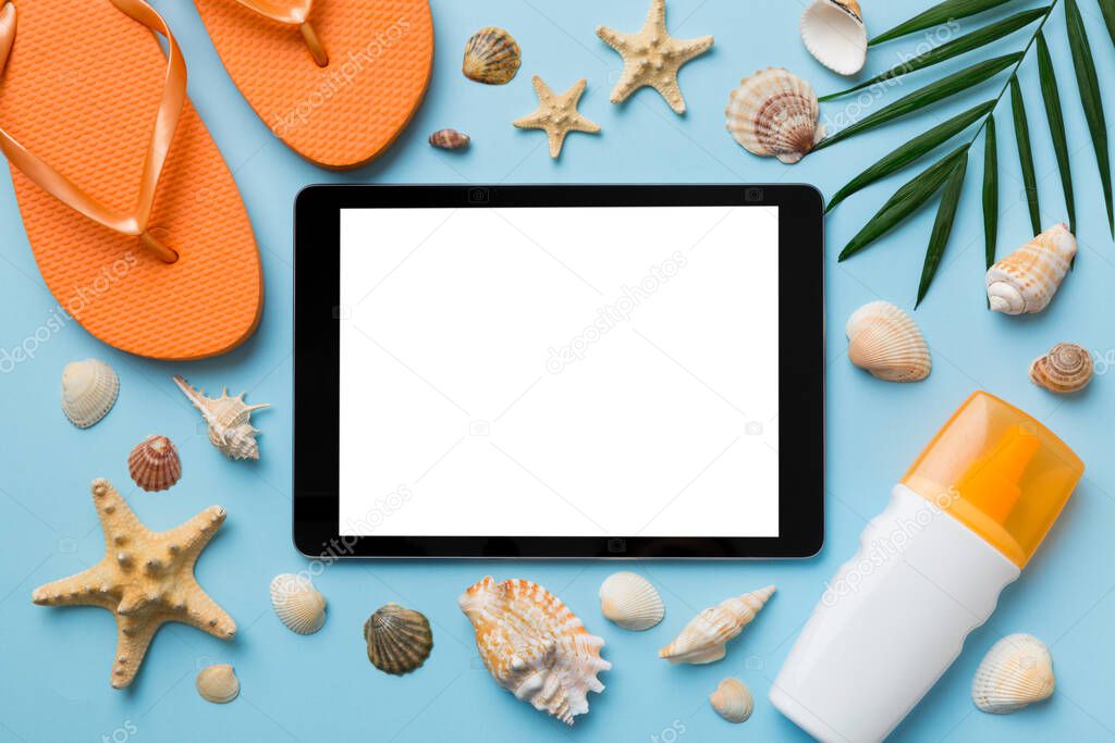 Flat lay composition with tablet and beach accessories on colored background. Tablet computer with blank screen mock up with copy space.