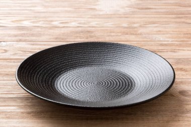 Ahşap zemindeki boş siyah plakanın perspektif görüntüsü. Tasarımın için boş boşluk.