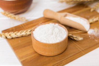 Tahta kasede buğday unu ve renkli arka planda buğday dikenleri. dünya buğday krizi.