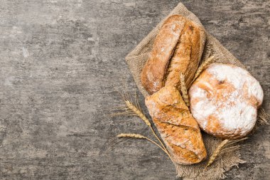 Kırsal masa manzaralı peçeteli taze pişmiş ekmek çeşitleri. Sağlıklı mayasız ekmek. Fransız ekmeği.