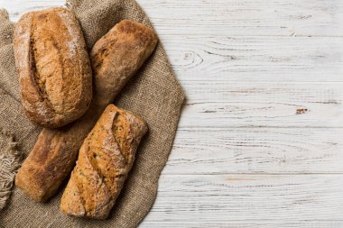 Kırsal masa manzaralı peçeteli taze pişmiş ekmek çeşitleri. Sağlıklı mayasız ekmek. Fransız ekmeği.