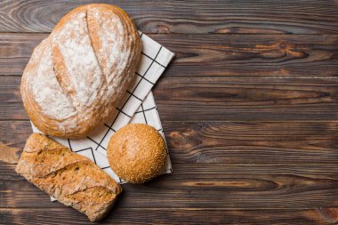 Kırsal masa manzaralı peçeteli taze pişmiş ekmek çeşitleri. Sağlıklı mayasız ekmek. Fransız ekmeği.