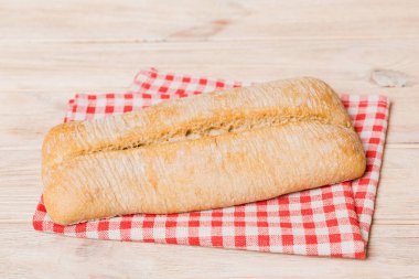 Kırsal masa manzaralı peçeteli taze pişmiş ekmek. Sağlıklı beyaz ekmek izole edilmiş..