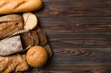 Ev yapımı doğal ekmek. Arka plan olarak farklı taze ekmek türleri, kopya alanı ile üst görünüm.