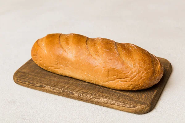 用白色木制背景在木板上烤好的新面包 透视面包与复制空间 — 图库照片