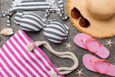 Kadın mayo ve plaj aksesuarları renkli arka plan yaz seyahati konseptine düz bir görünüm kazandırıyordu. Bikini mayo, hasır şapka ve deniz topuklu ayakkabı. Üst görünümü kopyala.